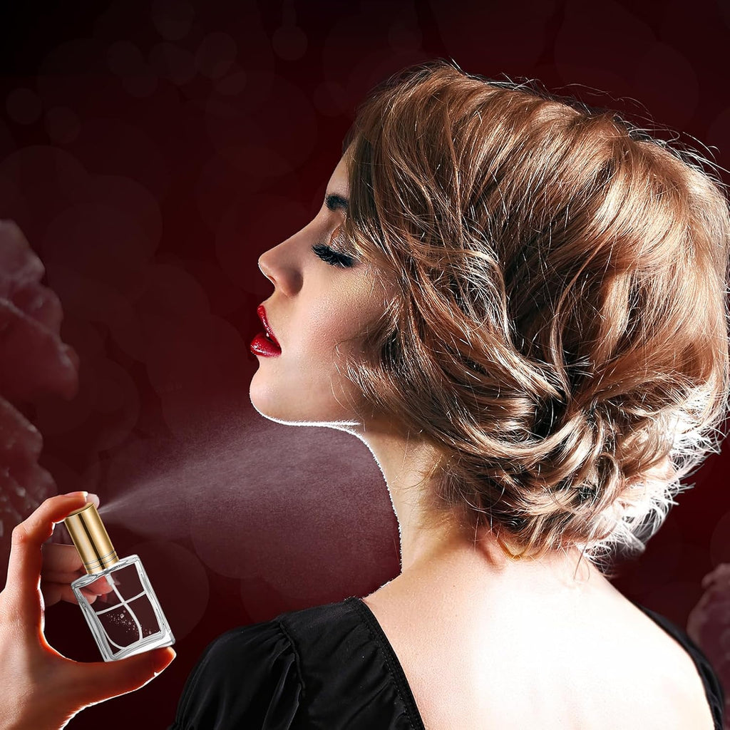 Woman spraying perfume with a glass perfume bottle against a dark blurred background
